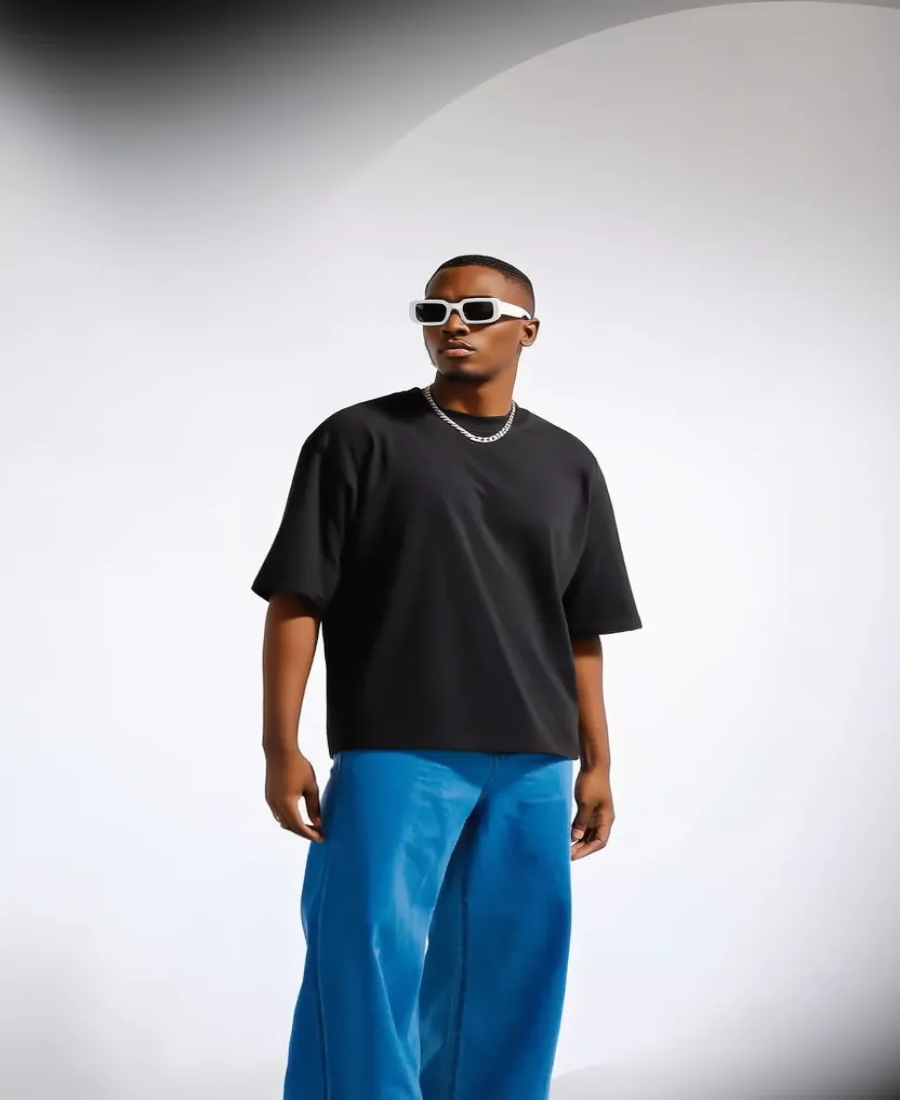 Person wearing a black t-shirt and blue pants with sunglasses on a white background