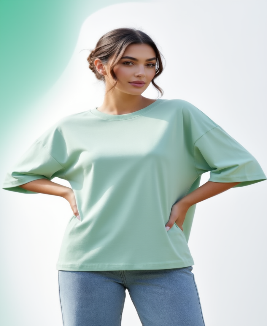 Woman wearing a light green oversized shirt with a blurred light green background