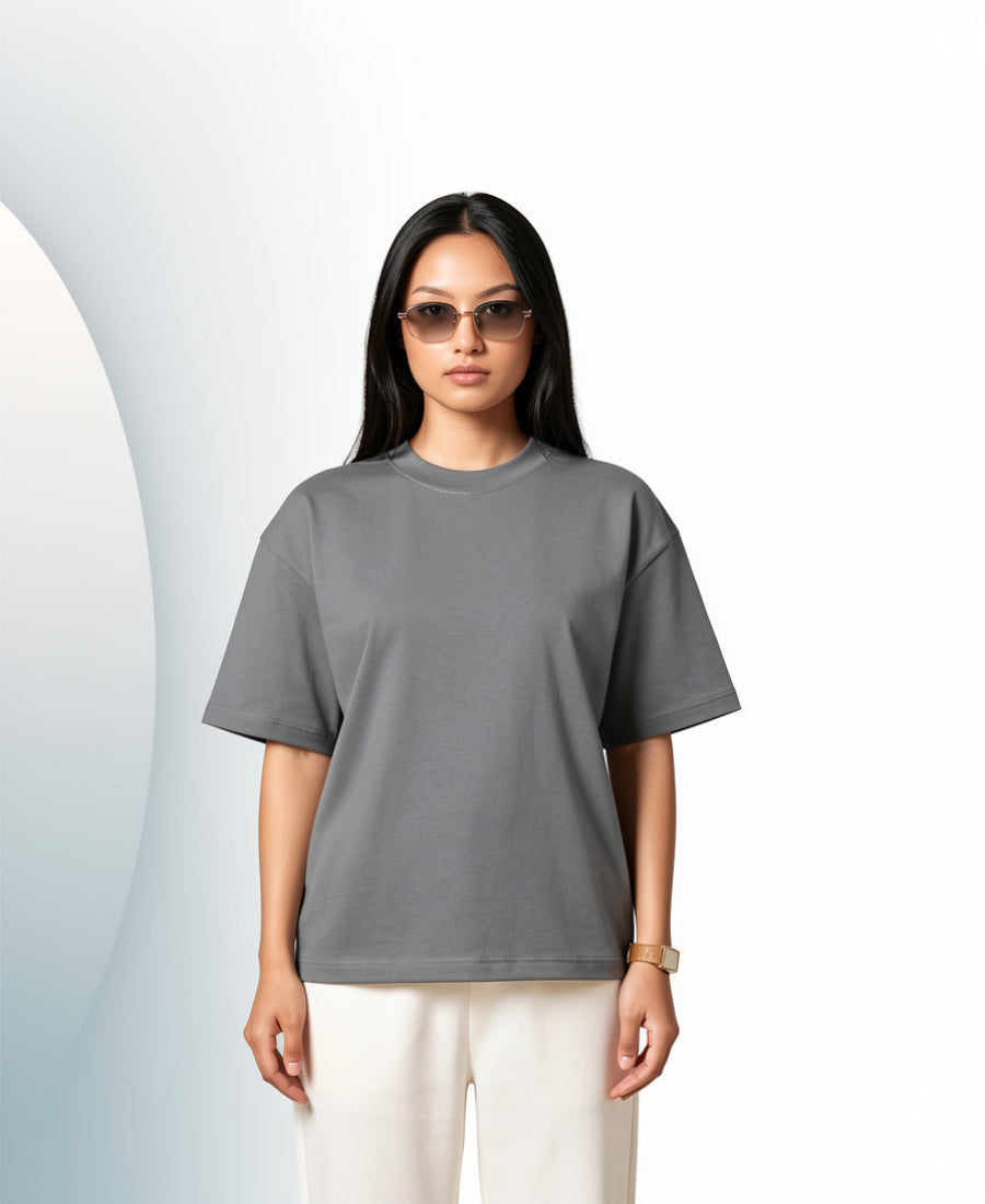 Woman wearing a gray t-shirt and sunglasses on a light background