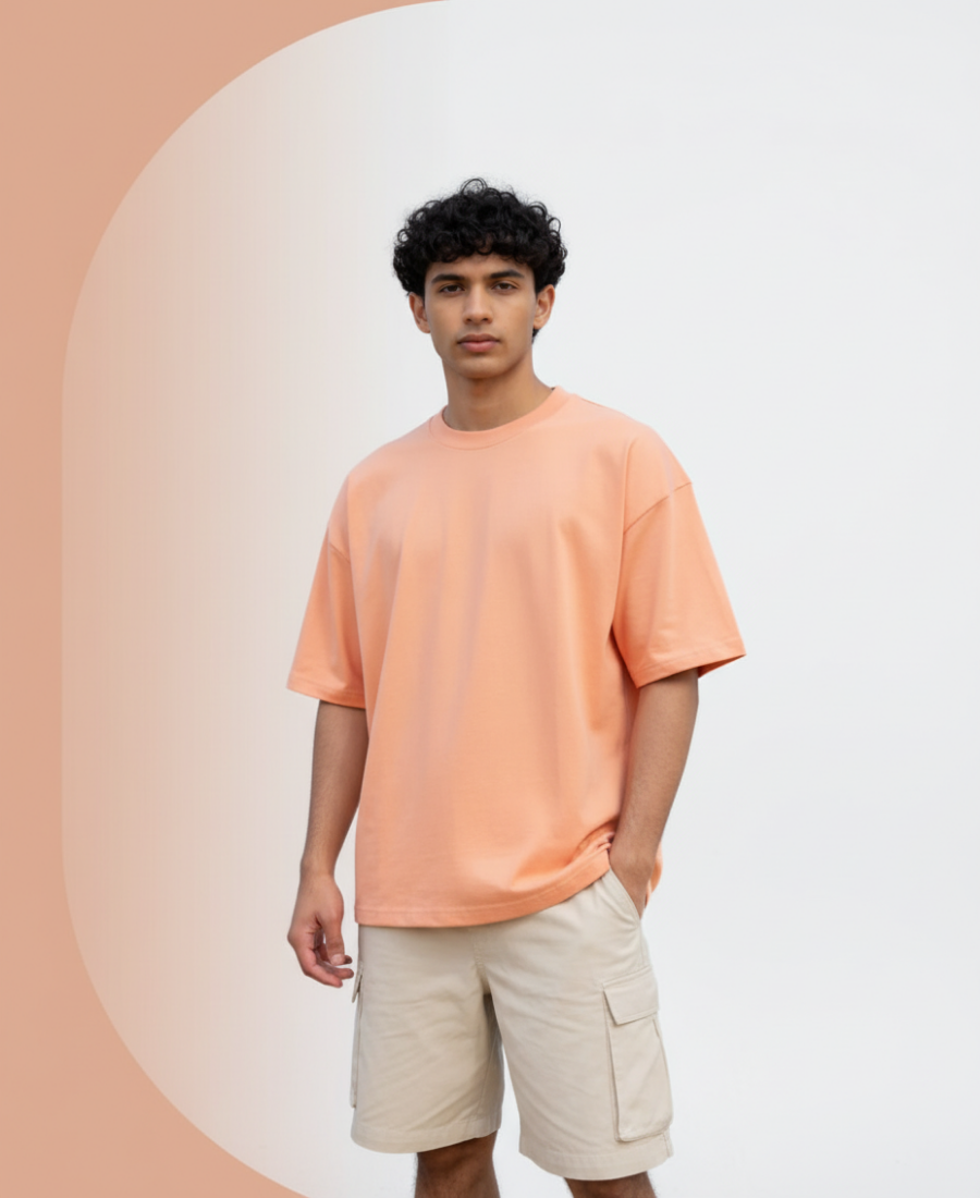 Person wearing an orange t-shirt and beige shorts against a gradient background