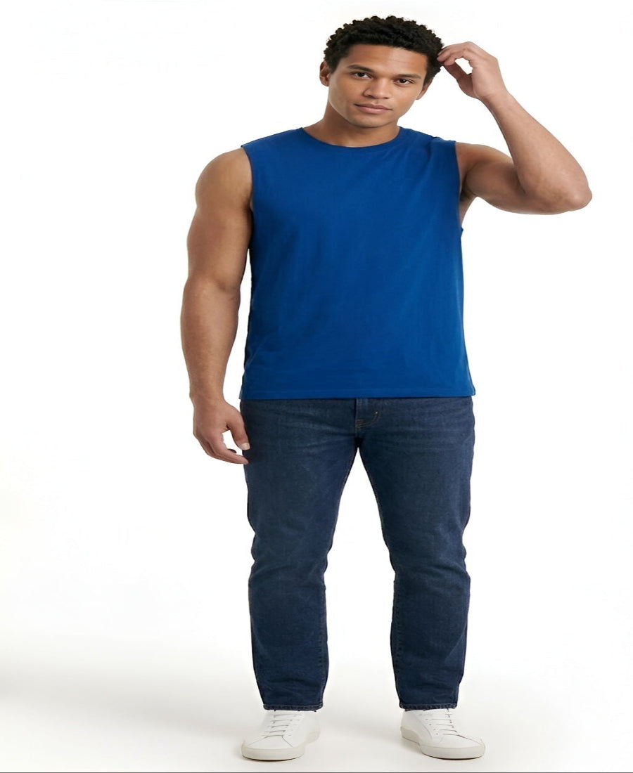 Man wearing a blue sleeveless shirt and dark jeans on a white background