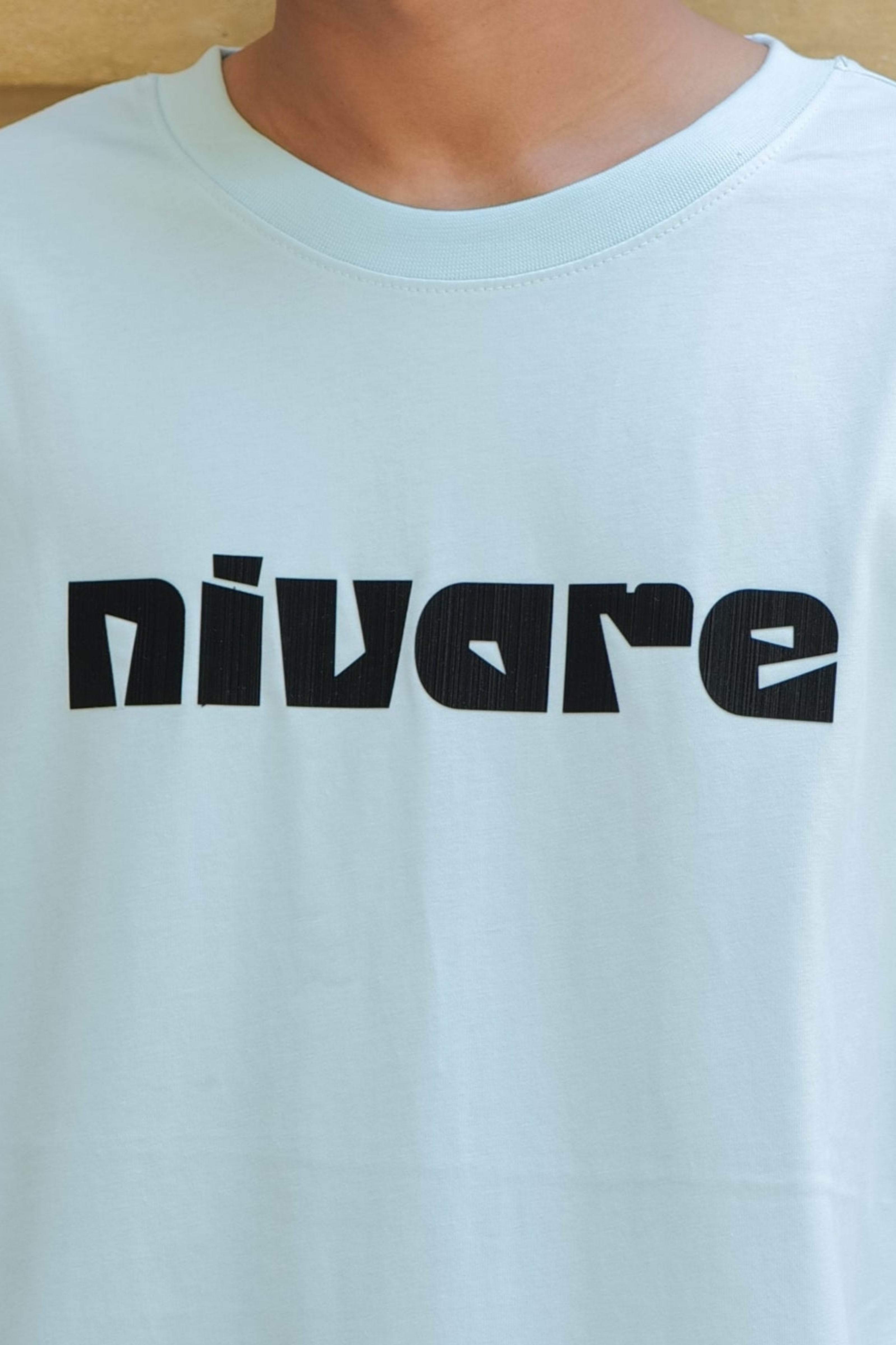 Light blue t-shirt with 'nivare' printed in black on a plain background