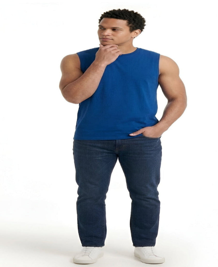 Man wearing a blue sleeveless shirt and dark jeans on a white background