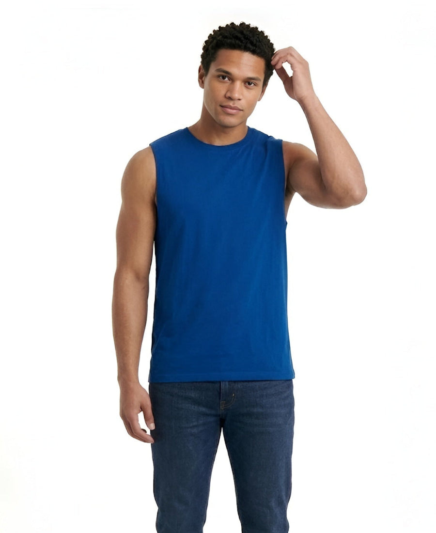 Man wearing a blue sleeveless shirt and dark jeans on a white background