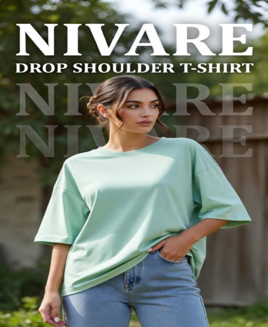 Woman wearing a light green drop shoulder t-shirt with 'NIVARE' branding.