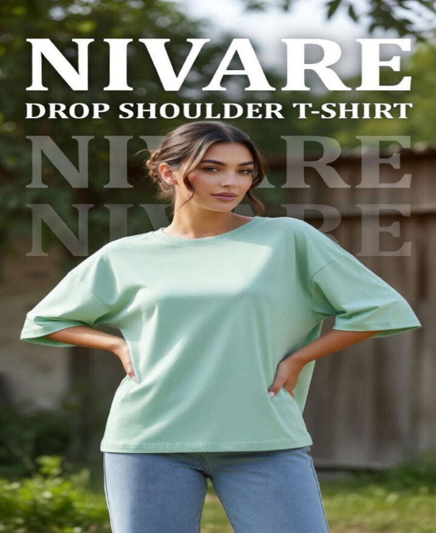 Woman wearing a light green drop shoulder t-shirt with 'NIVARE' branding.